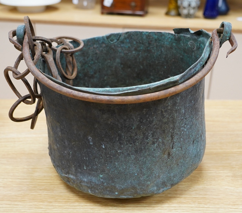 A 17th / 18th century copper cooking pot, 29cm to top of handle. Condition - poor